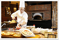 飯坂 ホテル聚楽 コックが窯焼きピザを盛り付けしている写真